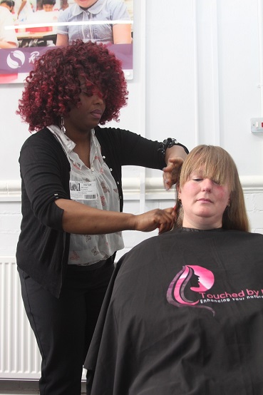 Ameyo starts to cut Corina’s hair
