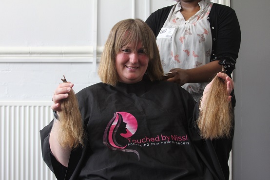 Corina holds up her chopped locks.